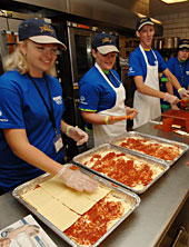 4-H'ers help assemble pans of lasagna for Special Olympics athletes.