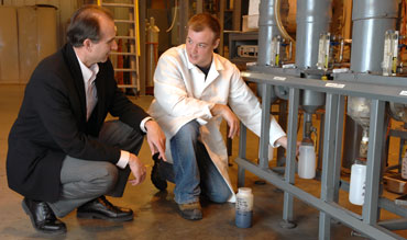 Robert C. Brown and graduate student Derek Wissmiller collect bio-oil from Iowa State University's fast pyrolysis equipment.