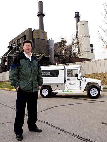 Iowa State's James McCalley with an electric vehicle and Iowa State's coal-fired power plant.