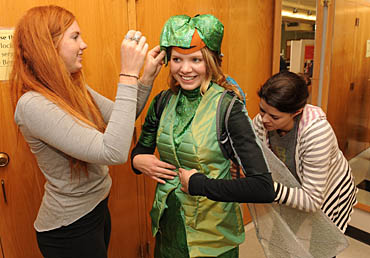 ISU apparel students Kaitlyn Clevenstine (left) and Marian Baggenstoss (right) apply the finishing touches to a dragonfly costume that will be worn by student dancer Laura Carr during the 